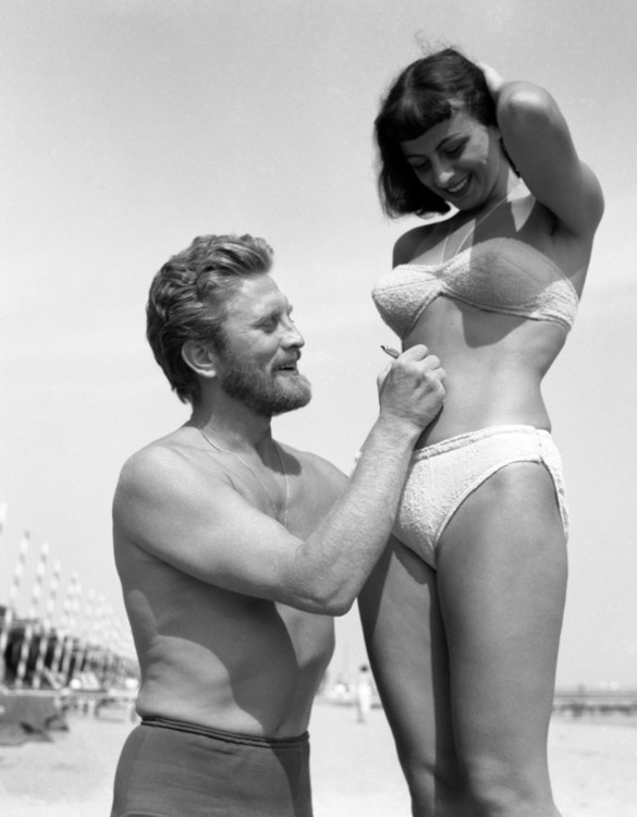 Кірк Дуглас підписує живіт шанувальниці на пляжі у Венеції, 1953