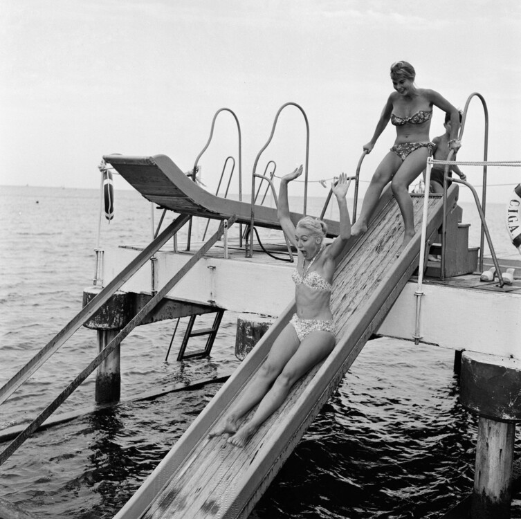 Керіл Ганн спускається з водної гірки, а за нею італійська акторка Маріса Алласіо, 1956