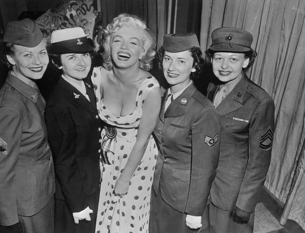 Мерилін Монро стоїть із жінками з армії США, ВМС, ВПС та Корпусу морської піхоти