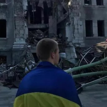 Фото дня: хлопець з прапором України біля розбомбленого Драмтеатру в Маріуполі