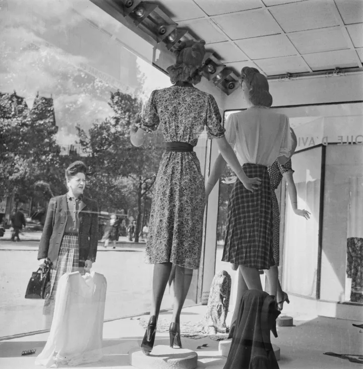 Жінка розглядає одяг у вітрині модного магазину в Парижі, Франція, після його звільнення від німецької окупації під час Другої світової війни 12 вересня 1944 року