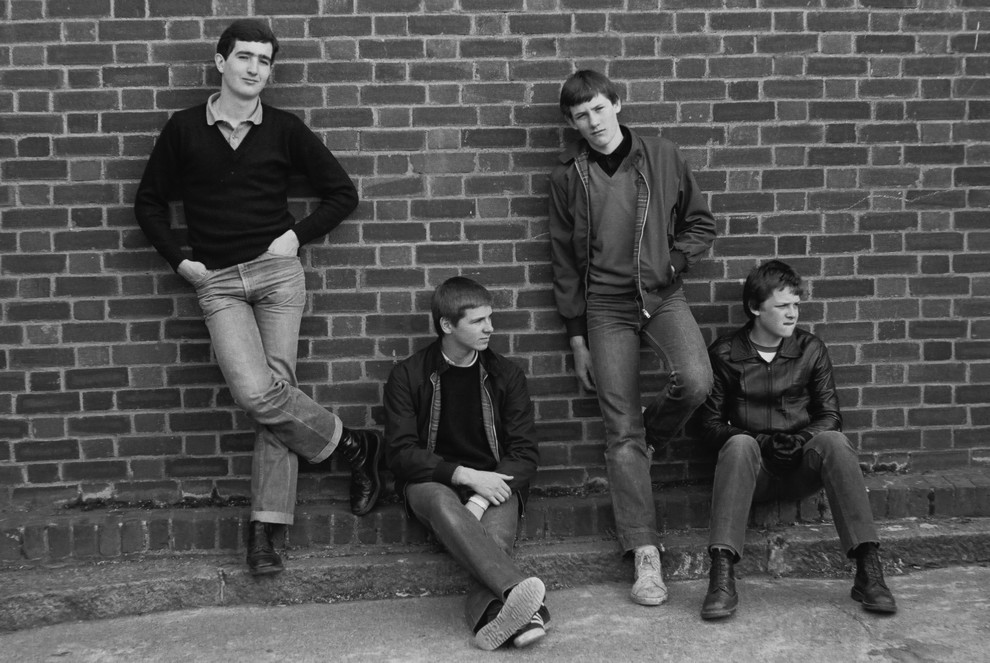 4 британских подростка позируют у кирпичной стены в 1980 году