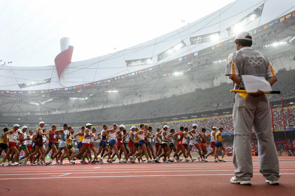 Спортсмены соревнуются в мужской ходьбе на 50 км на Национальном стадионе «Птичье гнездо» во время Олимпийских игр 2008 года в Пекине